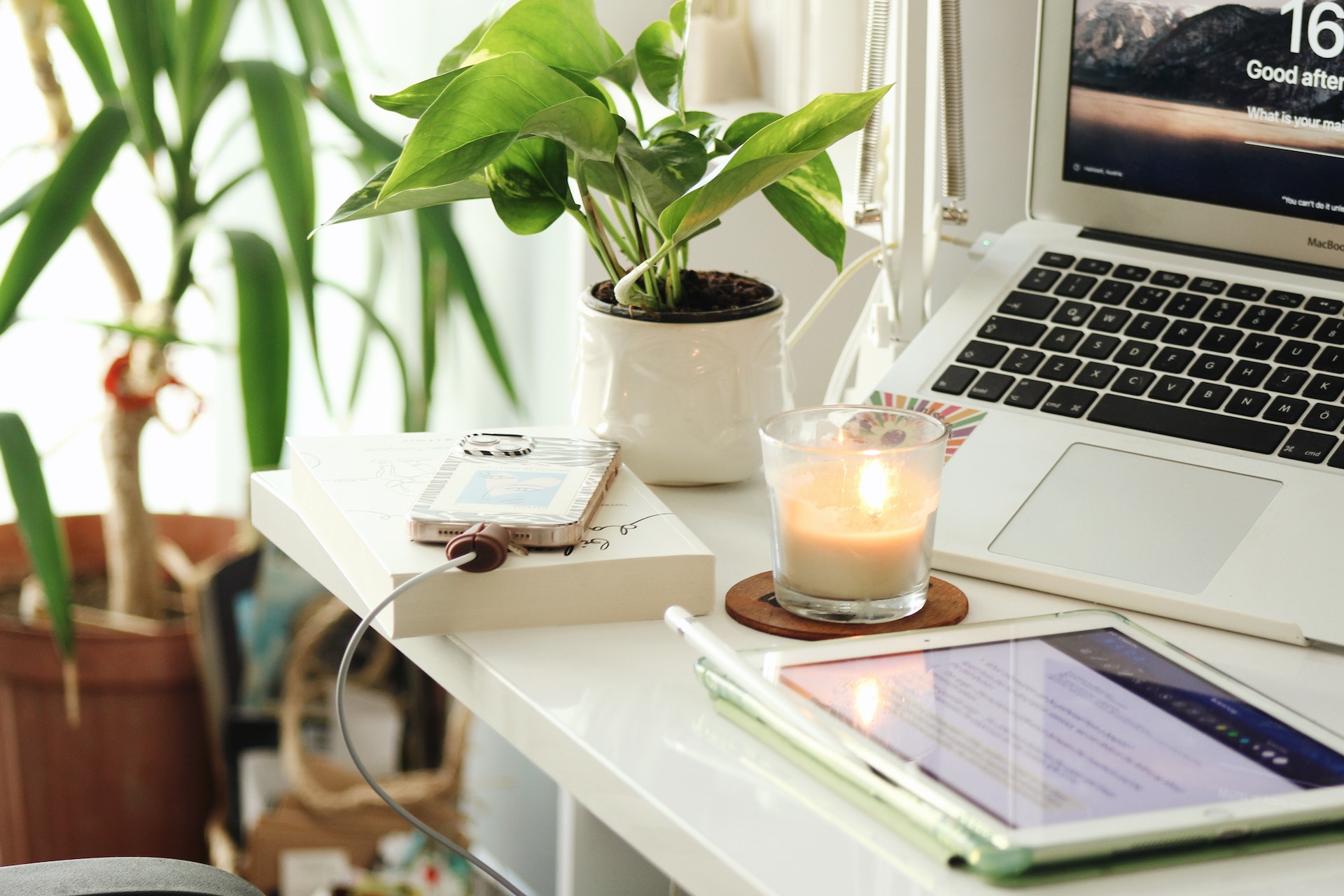 desk with laptop, candle, plant
